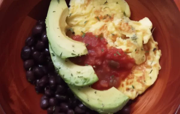 A hearty and nutritious breakfast bowl featuring black beans, avocado, eggs, and salsa.