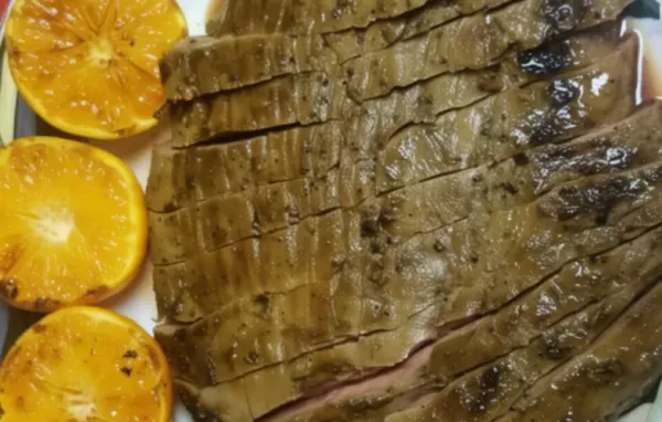 Tender flank steak marinated in a flavorful garlic and fennel rub, served with citrusy orange slices.