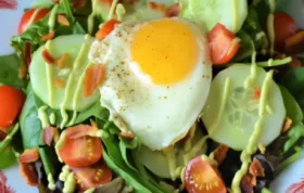 Delicious and satisfying breakfast salad with crispy bacon, eggs, and creamy avocado dressing.